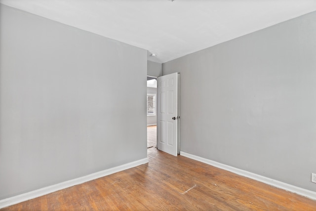 spare room featuring baseboards and wood finished floors