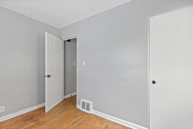 unfurnished bedroom featuring light wood finished floors, baseboards, and visible vents