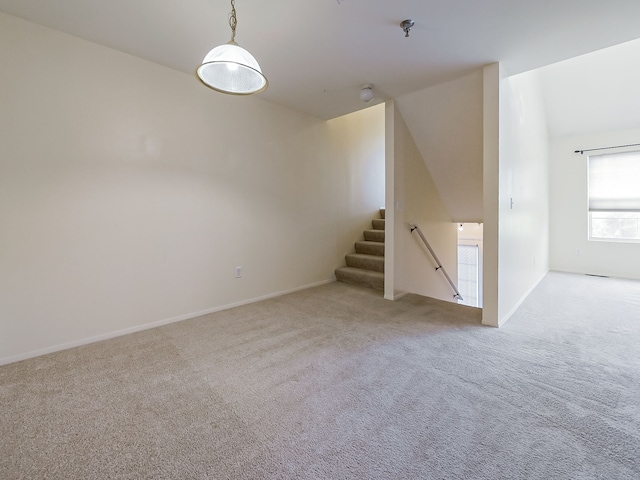 interior space with light carpet, vaulted ceiling, and stairs