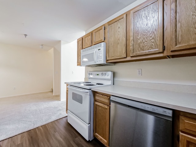 kitchen featuring white appliances, open floor plan, light countertops, brown cabinets, and dark wood finished floors