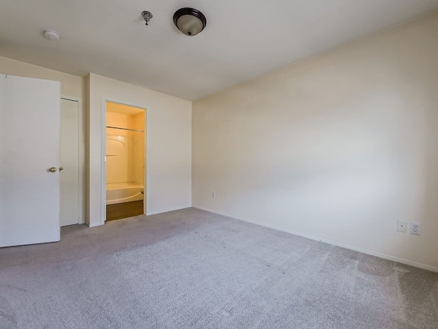 unfurnished bedroom with light carpet and ensuite bathroom