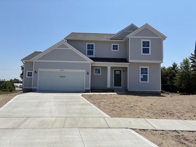 1973 Lowe Dr, Spring Lake, MI 49456 - view of front of house with driveway, a garage, and a porch