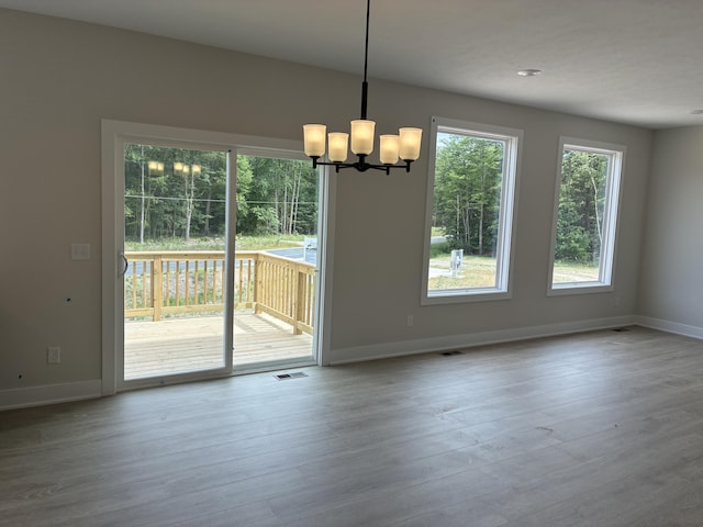 1973 Lowe Dr, Spring Lake, MI 49456 - unfurnished dining area featuring a chandelier and wood finished floors