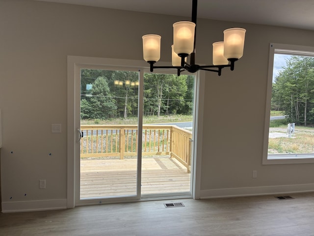 1973 Lowe Dr, Spring Lake, MI 49456 - doorway to outside with a chandelier, healthy amount of natural light, and wood finished floors
