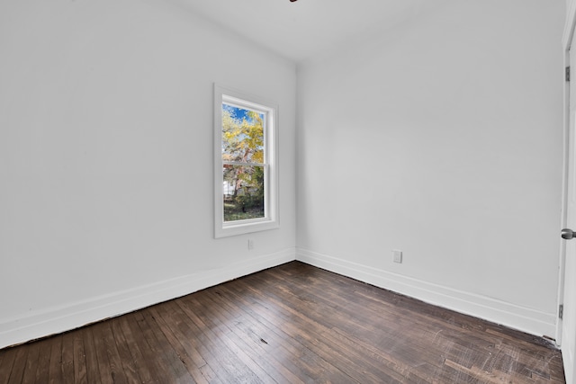 empty room featuring dark wood finished floors and baseboards