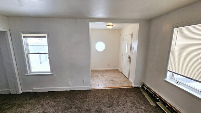 foyer entrance with carpet and baseboards