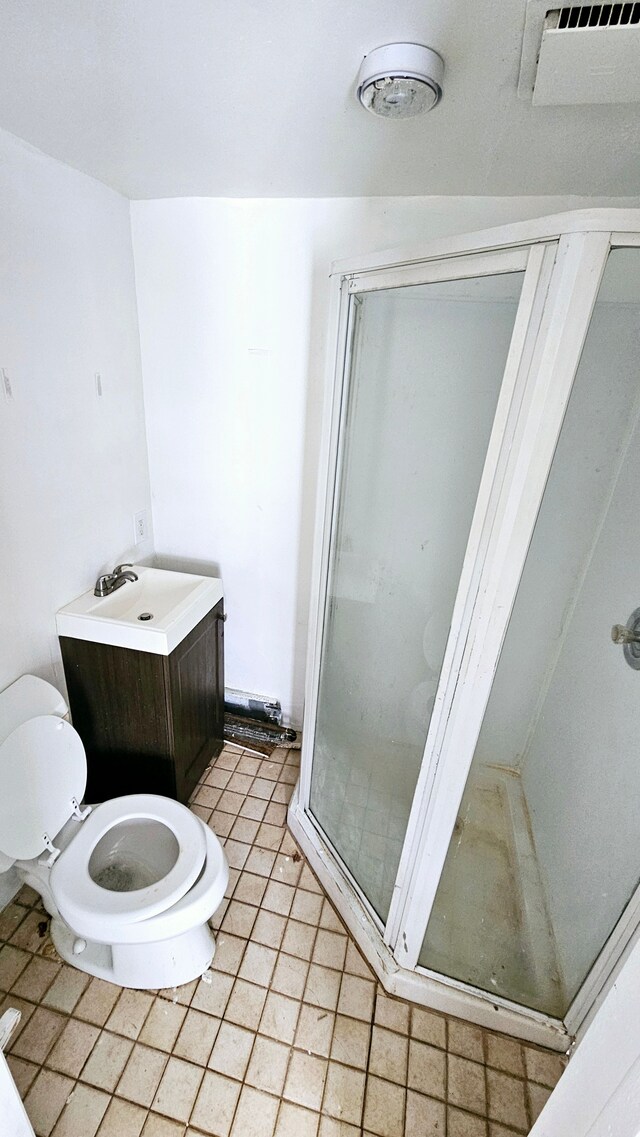 bathroom with vanity, tile patterned flooring, a shower stall, and toilet