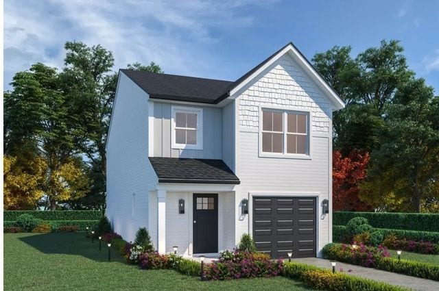 view of front of property featuring a garage and a front lawn