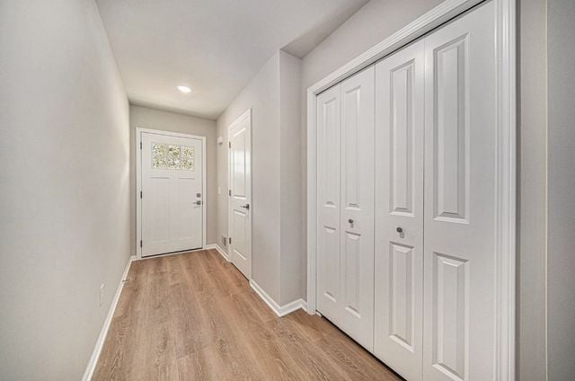 doorway with light wood-style flooring and baseboards