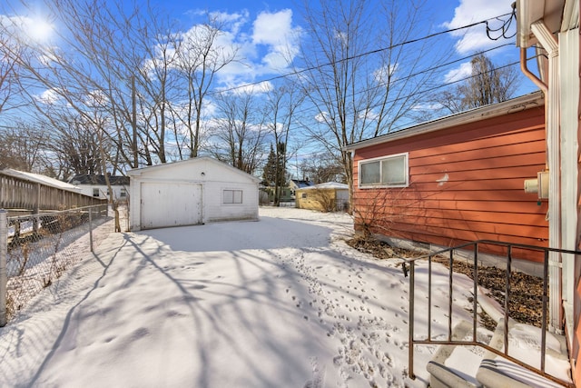 yard layered in snow featuring an outbuilding and fence