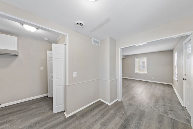 spare room featuring dark wood-style floors, baseboards, and visible vents