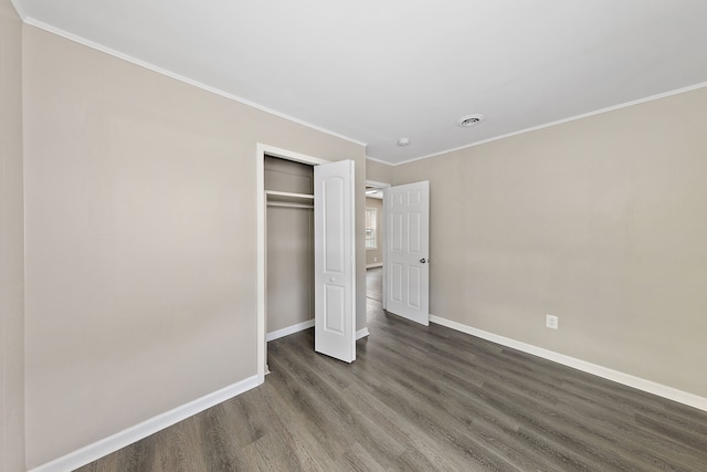 unfurnished bedroom featuring dark wood finished floors, a closet, visible vents, ornamental molding, and baseboards