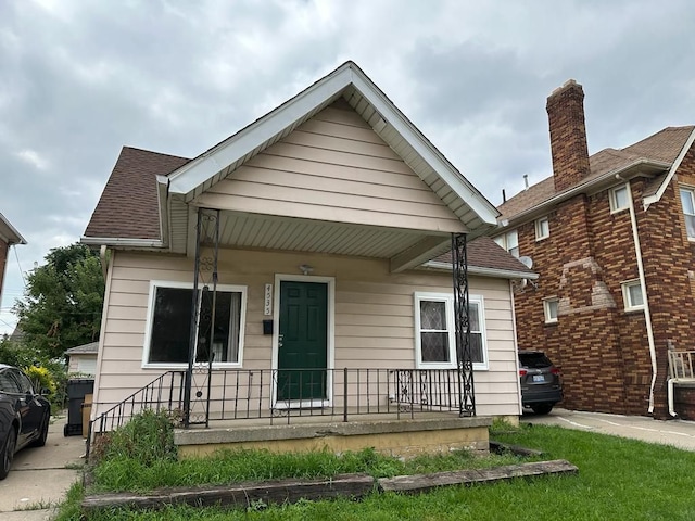 bungalow-style house with covered porch and roof with shingles