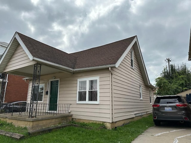 view of front of home with covered porch and a shingled roof