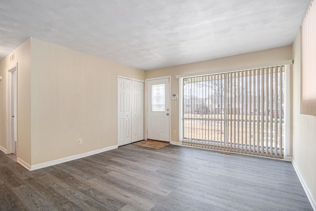 interior space with wood finished floors, visible vents, and baseboards