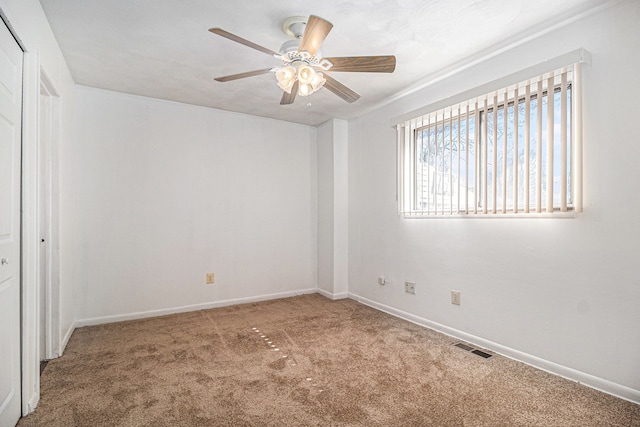 interior space featuring ceiling fan, carpet flooring, visible vents, and baseboards