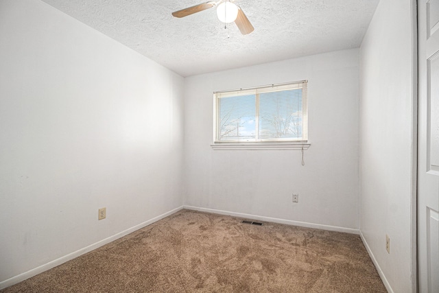 carpeted empty room with baseboards, a textured ceiling, visible vents, and a ceiling fan