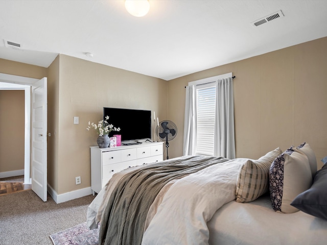 bedroom featuring baseboards, visible vents, and light colored carpet