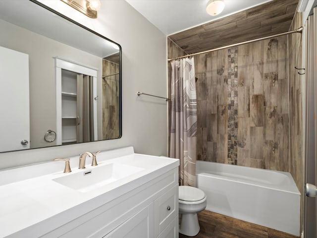 bathroom featuring shower / bath combination with curtain, vanity, toilet, and wood finished floors