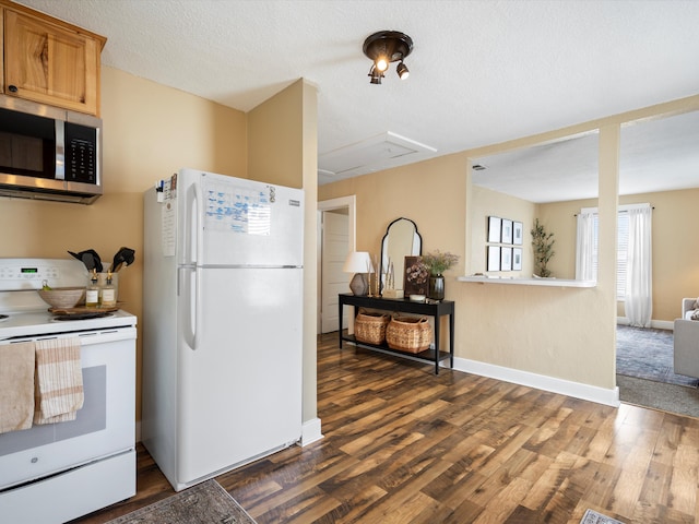 kitchen with white appliances, baseboards, dark wood-style floors, and a textured ceiling