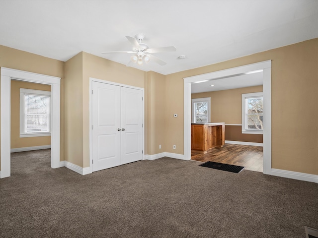 interior space with a ceiling fan, carpet, a closet, and baseboards