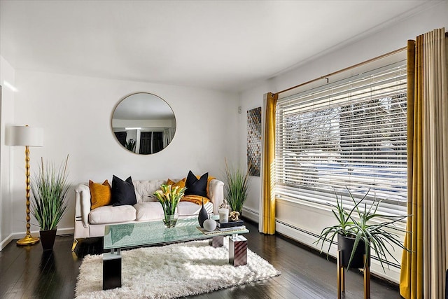 living room with dark wood-style floors, a baseboard heating unit, and baseboards