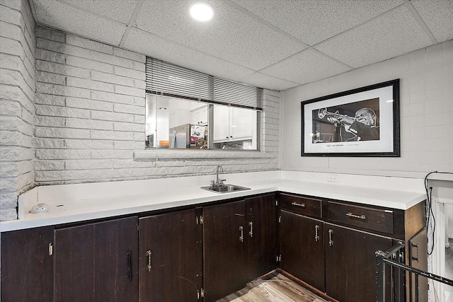 bathroom with a drop ceiling, a sink, and wood finished floors