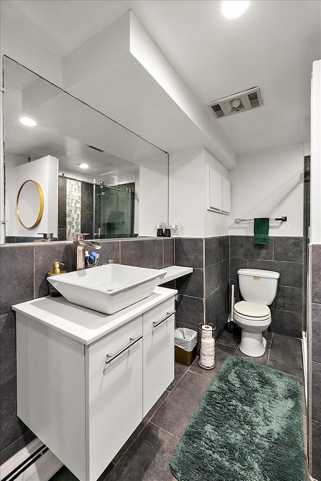 bathroom featuring tile walls, visible vents, toilet, a stall shower, and vanity