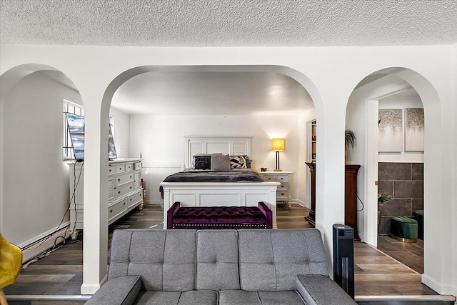 bedroom featuring a textured ceiling and dark wood finished floors