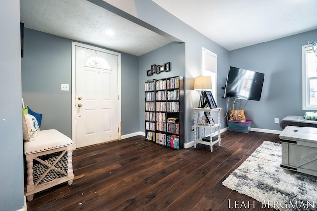 foyer entrance featuring dark wood-style flooring and baseboards