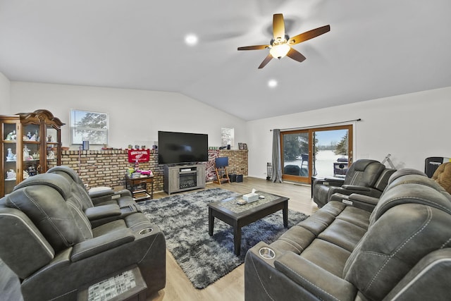 living area featuring lofted ceiling, plenty of natural light, and light wood-style flooring