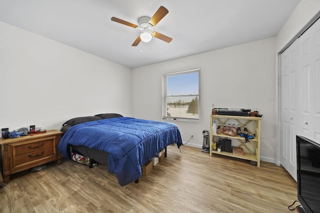 bedroom with a ceiling fan, a closet, baseboards, and light wood finished floors