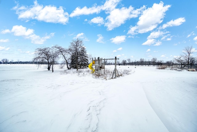 yard layered in snow featuring a playground