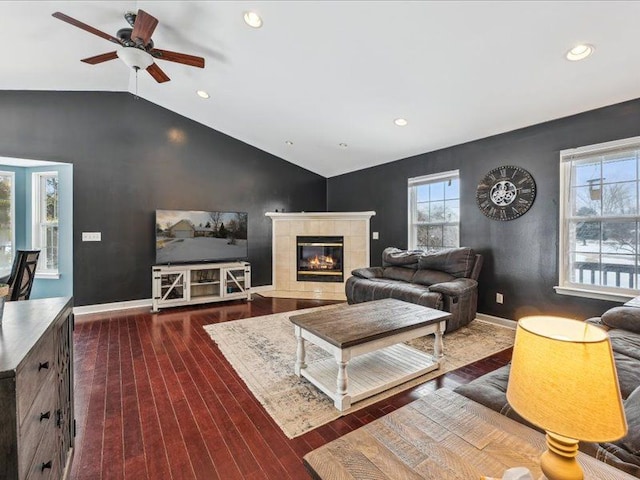 living area featuring baseboards, a tile fireplace, lofted ceiling, dark wood-style floors, and recessed lighting