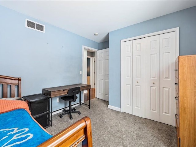 carpeted bedroom with a closet, visible vents, and baseboards