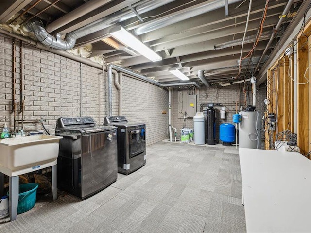 unfinished basement with light carpet, brick wall, a sink, washer and dryer, and water heater