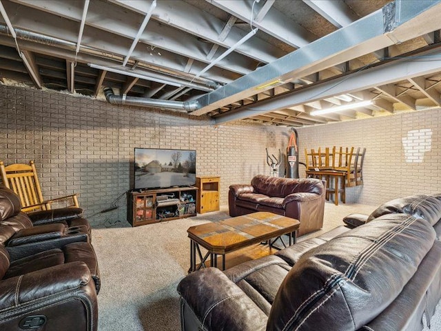 carpeted living area featuring brick wall