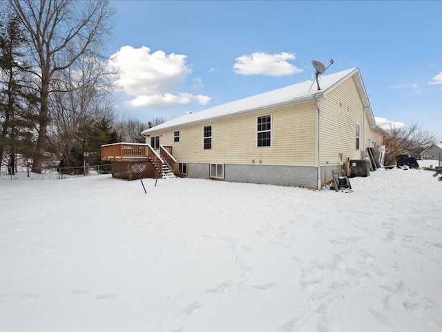 snow covered property featuring stairway and a deck