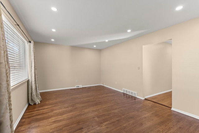 spare room with recessed lighting, dark wood-style flooring, visible vents, and baseboards