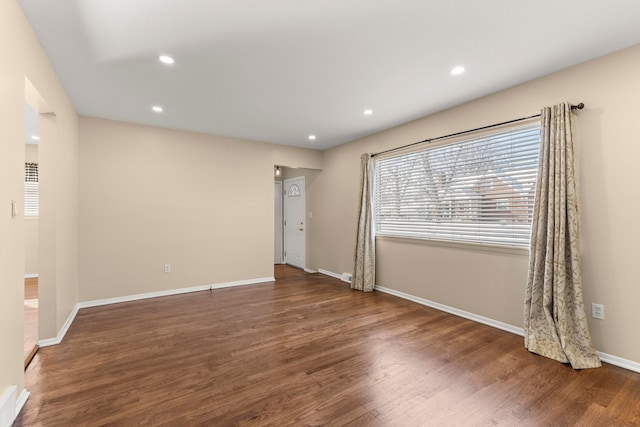 empty room featuring baseboards, dark wood finished floors, and recessed lighting