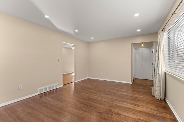 empty room featuring recessed lighting, visible vents, and wood finished floors