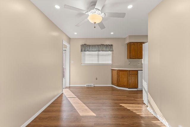 interior space with brown cabinetry, light countertops, light wood-style floors, and visible vents