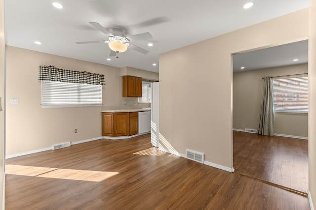 unfurnished living room with wood finished floors, visible vents, and baseboards