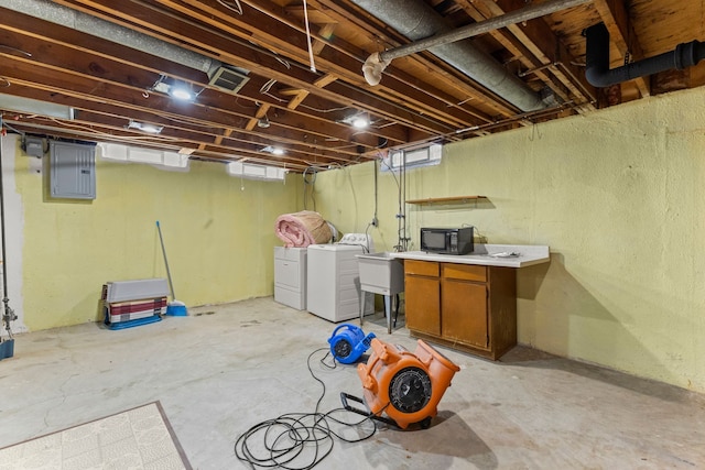 below grade area featuring washing machine and dryer, electric panel, visible vents, and a sink