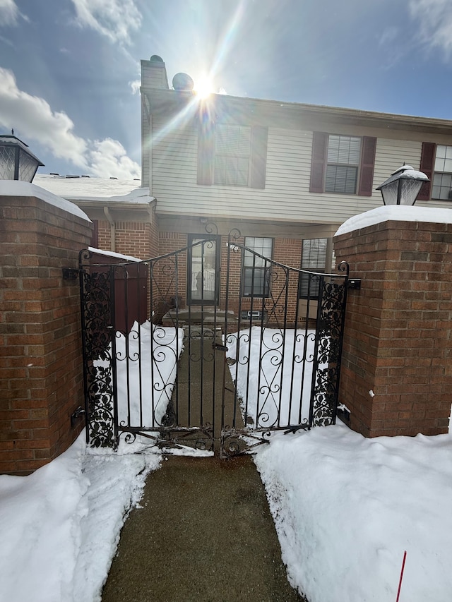 snow covered gate featuring a fenced front yard