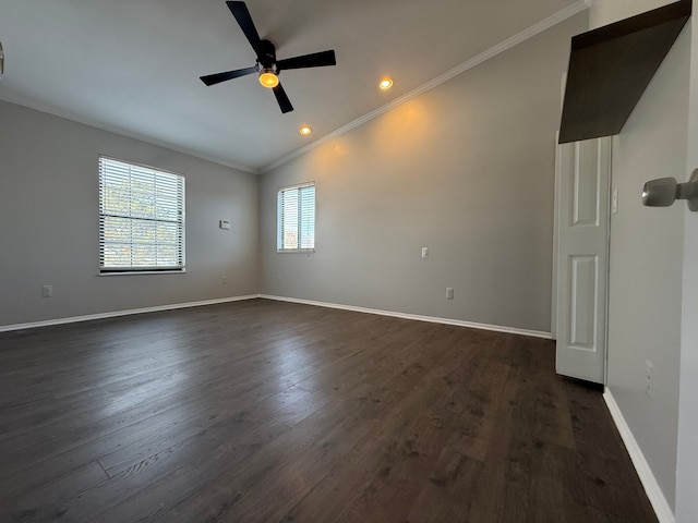 empty room featuring dark wood-style floors, ornamental molding, a ceiling fan, vaulted ceiling, and baseboards