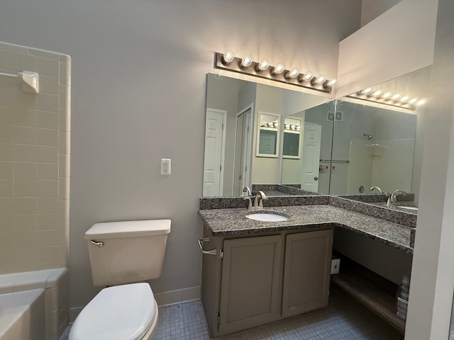 bathroom featuring a tub to relax in, toilet, vanity, baseboards, and tile patterned floors