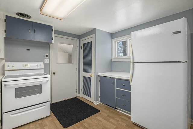 kitchen with light countertops, white appliances, visible vents, and light wood-style flooring