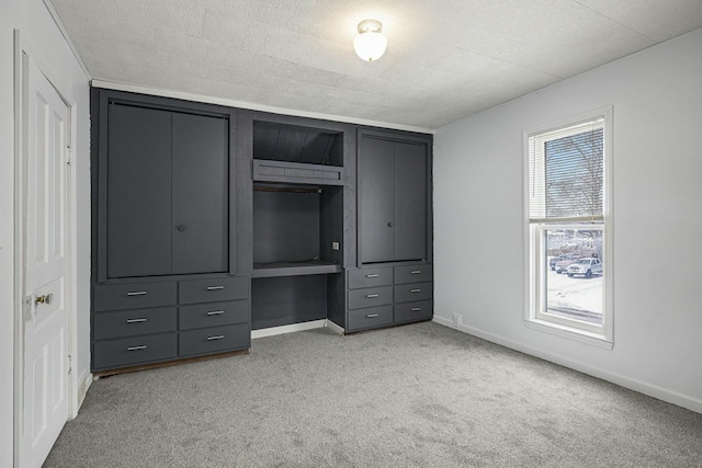 unfurnished bedroom with light carpet, baseboards, and a textured ceiling