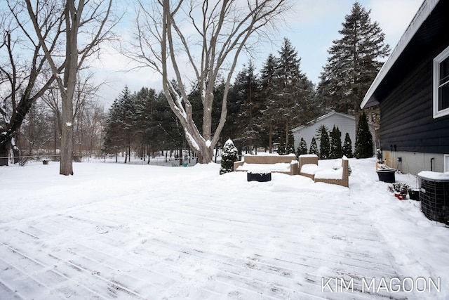 yard layered in snow featuring central AC unit